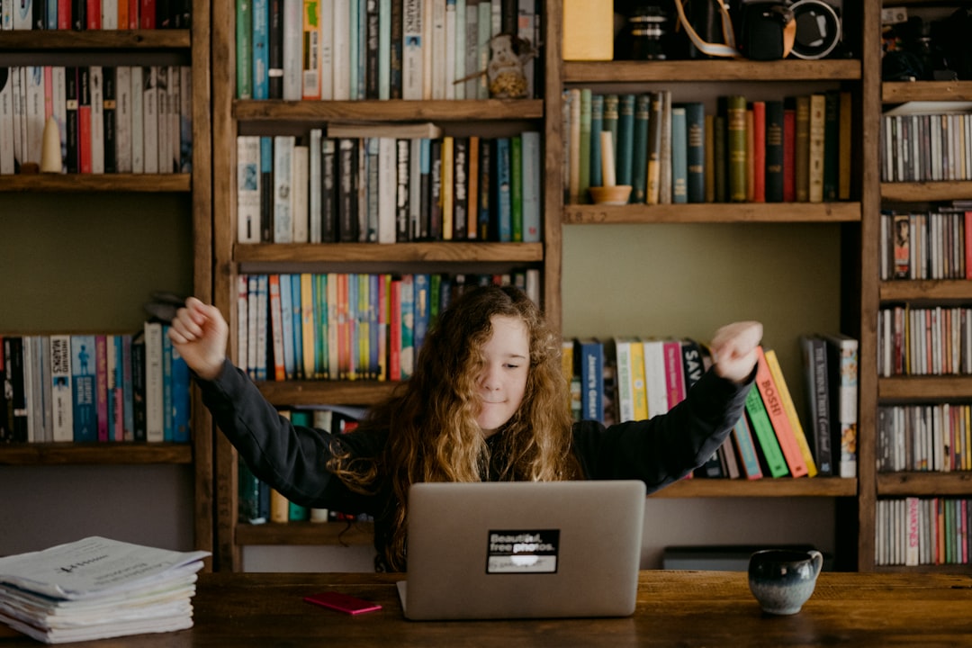 woman in black long sleeve shirt sitting in front of silver macbook woman in black long sleeve shirt sitting in front of silver macbook